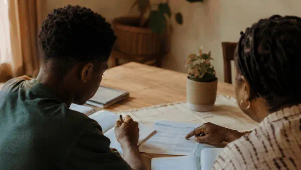 Grade 9 learner and parent discussing subject choices together at a dining table
