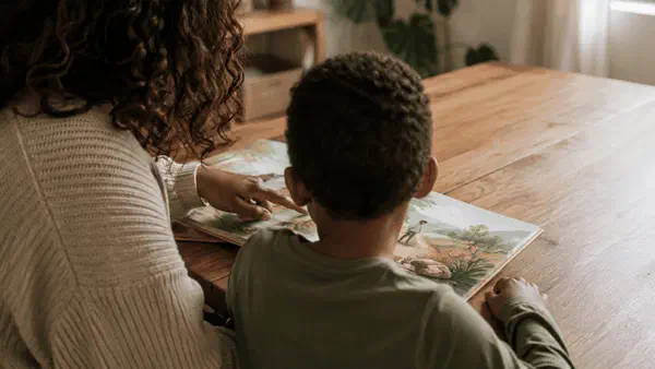 Child reading with a parent at home, with the child's face turned away